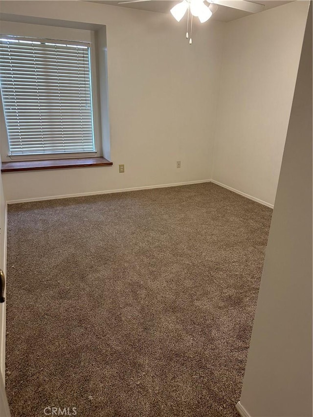 unfurnished room with a ceiling fan, carpet, and baseboards
