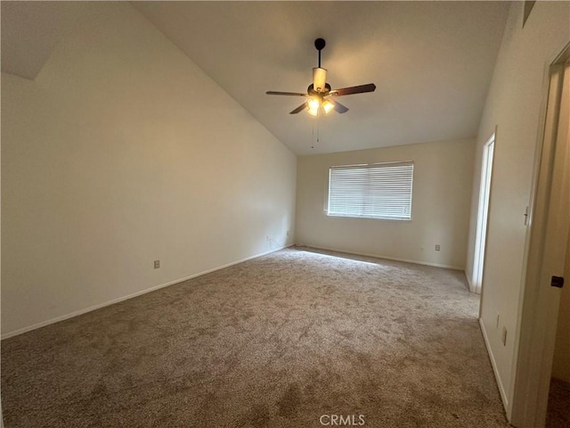 carpeted empty room with baseboards, vaulted ceiling, and a ceiling fan