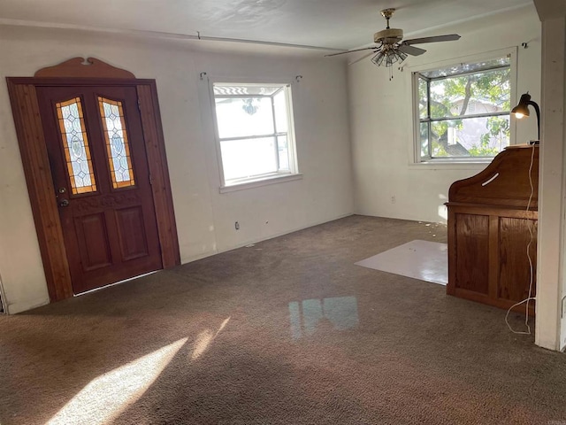 carpeted entrance foyer featuring a wealth of natural light and ceiling fan