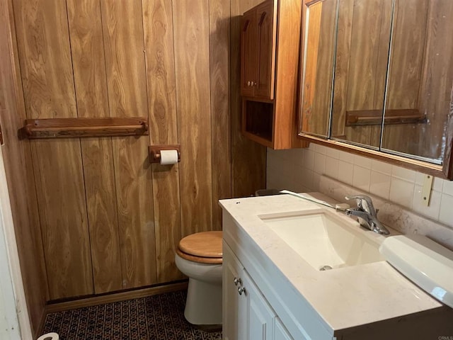 bathroom featuring vanity, backsplash, and toilet