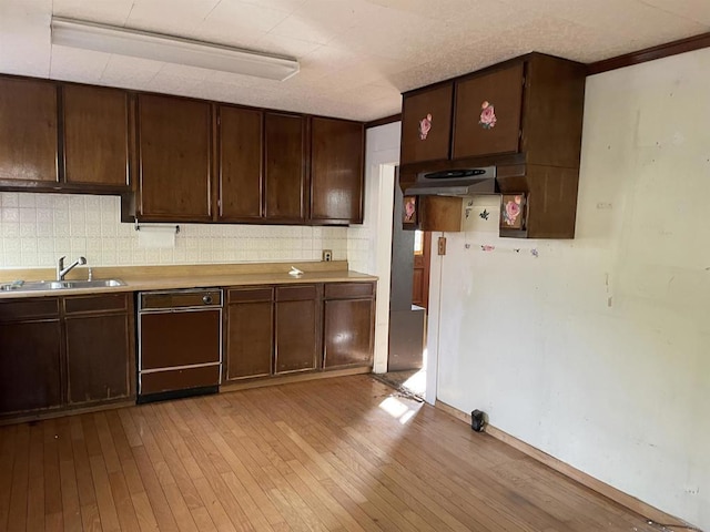 kitchen with sink, dark brown cabinets, light hardwood / wood-style flooring, and decorative backsplash