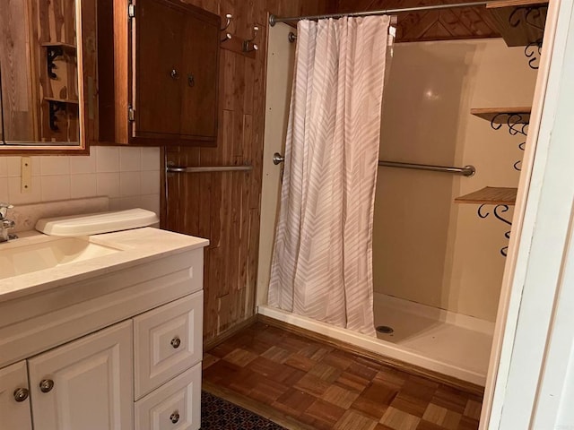 bathroom featuring parquet floors, vanity, a shower with shower curtain, and decorative backsplash