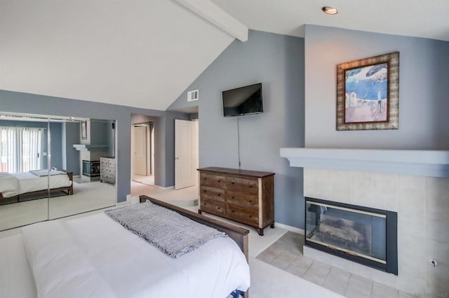 bedroom featuring light carpet, a fireplace, and lofted ceiling with beams