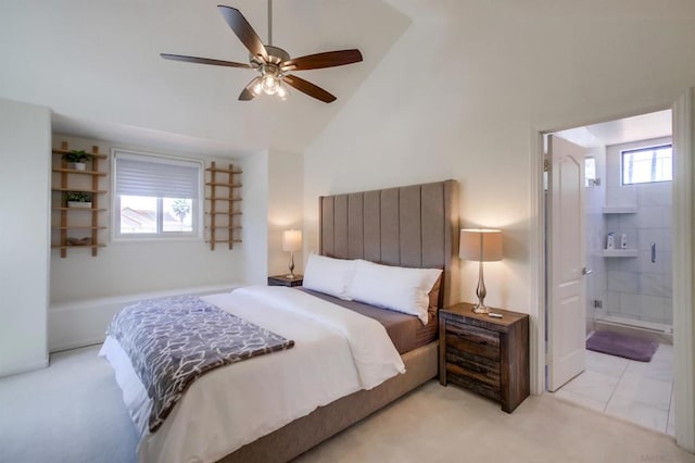 bedroom with vaulted ceiling, light colored carpet, ensuite bathroom, and ceiling fan