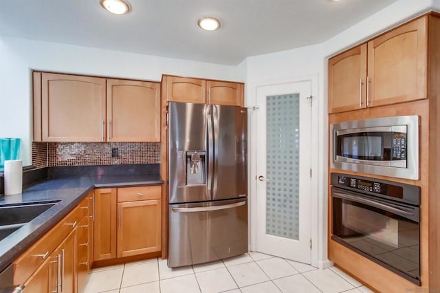 kitchen featuring tasteful backsplash, light tile patterned floors, and appliances with stainless steel finishes