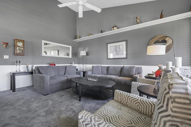 living room with carpet, a towering ceiling, and ceiling fan