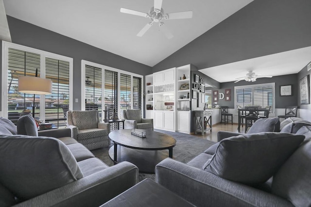 living room featuring hardwood / wood-style floors, high vaulted ceiling, and ceiling fan