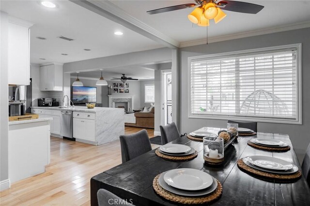 3140 Sumatra Pl, Costa Mesa, CA 92626 - dining space with a ceiling fan, light wood-style flooring, ornamental molding, a fireplace, and recessed lighting