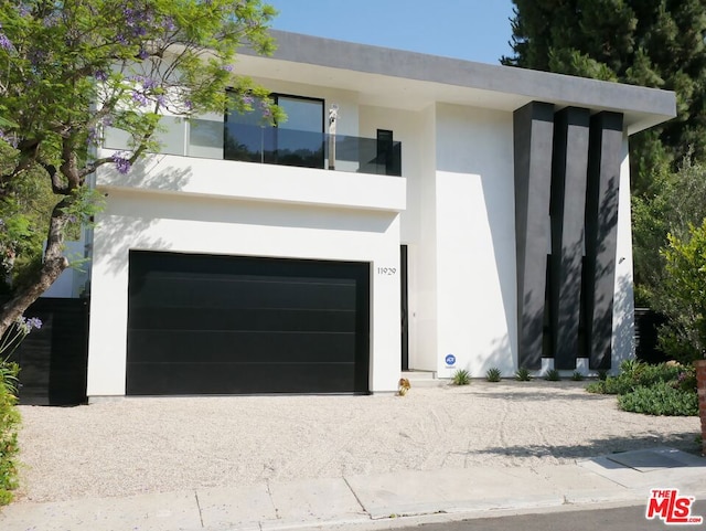 contemporary house with a garage and a balcony