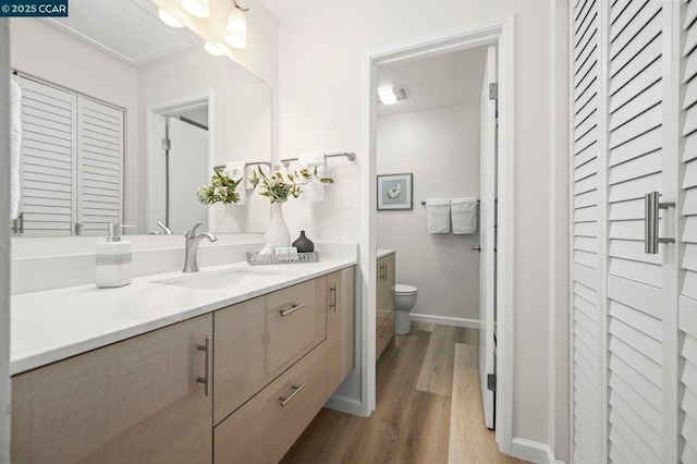 bathroom featuring vanity, toilet, and hardwood / wood-style floors