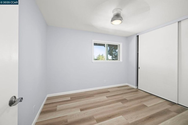 unfurnished bedroom with a closet and light hardwood / wood-style flooring