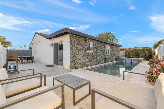 view of pool with grilling area and a patio