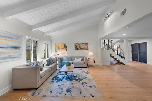 living room with beam ceiling, high vaulted ceiling, and light hardwood / wood-style flooring