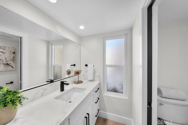 bathroom featuring vanity, hardwood / wood-style floors, and toilet