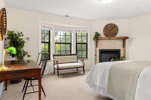 carpeted bedroom with a tiled fireplace