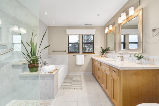 bathroom featuring vanity, tiled bath, and tile patterned flooring