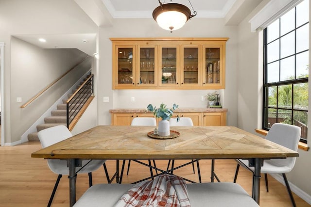 dining space featuring crown molding, plenty of natural light, and light hardwood / wood-style floors