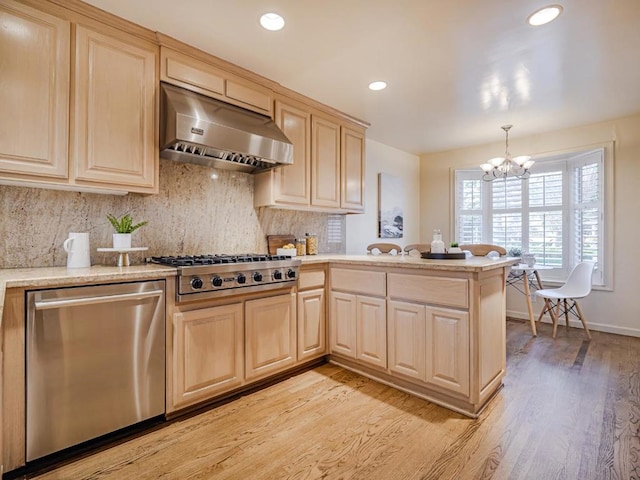 kitchen with wall chimney exhaust hood, appliances with stainless steel finishes, kitchen peninsula, pendant lighting, and decorative backsplash