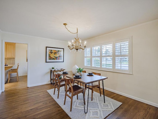 dining area with crown molding, dark hardwood / wood-style floors, and an inviting chandelier