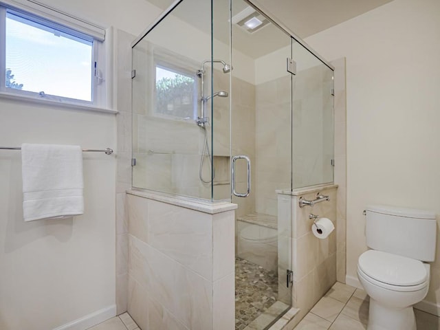 bathroom with an enclosed shower, tile patterned floors, and toilet