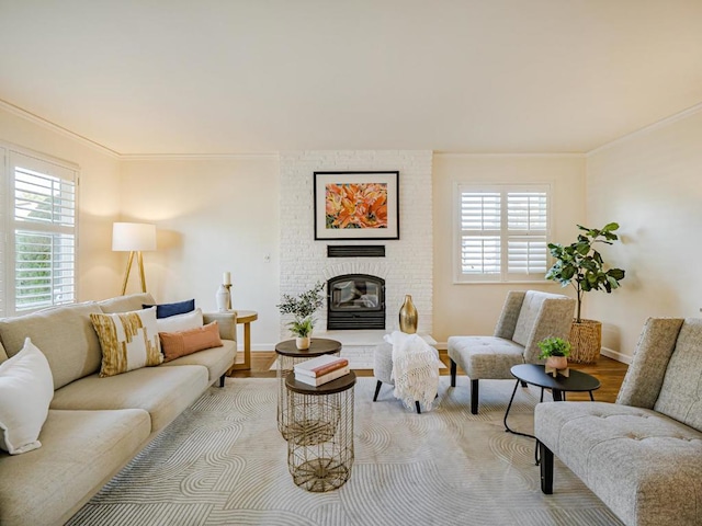 living room featuring ornamental molding, a brick fireplace, and light hardwood / wood-style flooring