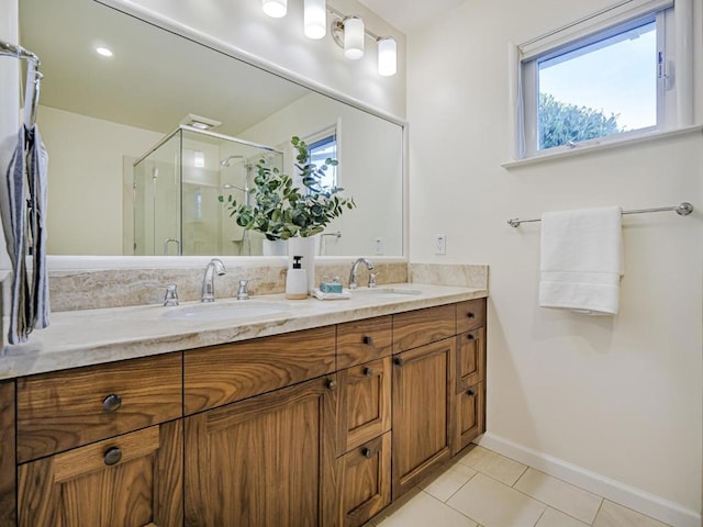 bathroom with vanity, a shower with door, tile patterned flooring, and a wealth of natural light