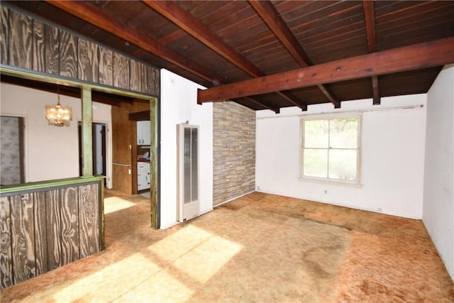 carpeted empty room with an inviting chandelier, wood ceiling, and lofted ceiling with beams