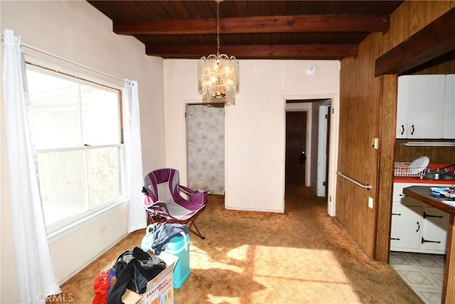 dining space featuring an inviting chandelier, plenty of natural light, and beam ceiling