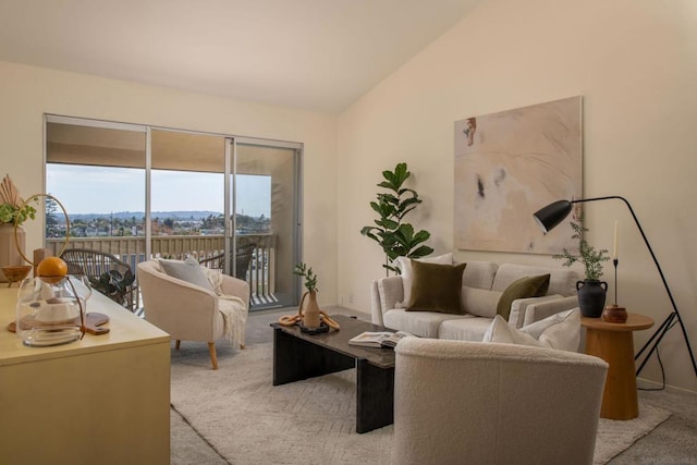 living room with vaulted ceiling, a mountain view, and light carpet