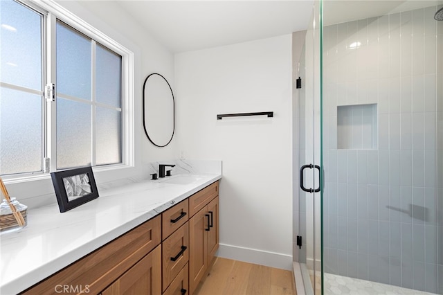 bathroom featuring vanity, a shower with door, and wood-type flooring