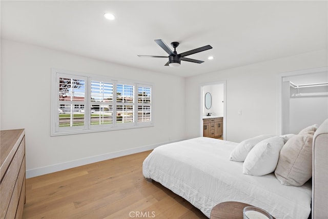 bedroom with ceiling fan, connected bathroom, and light hardwood / wood-style floors