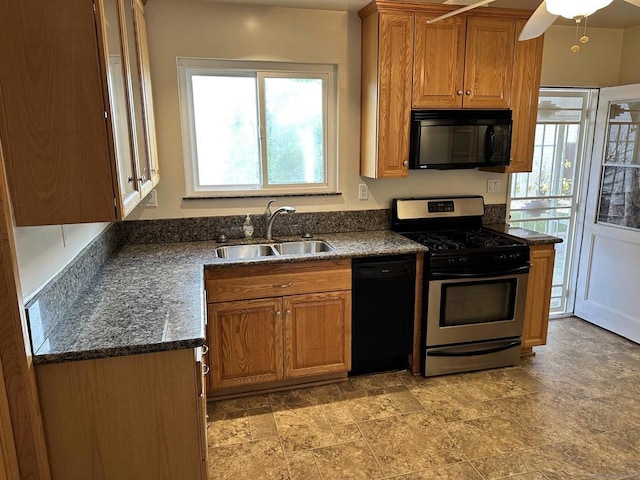 kitchen with dark stone countertops, plenty of natural light, sink, and black appliances