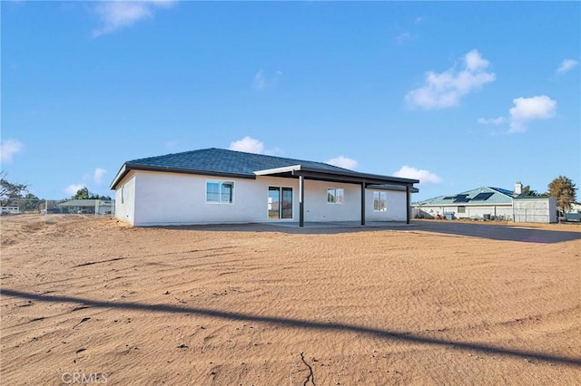 rear view of property featuring stucco siding