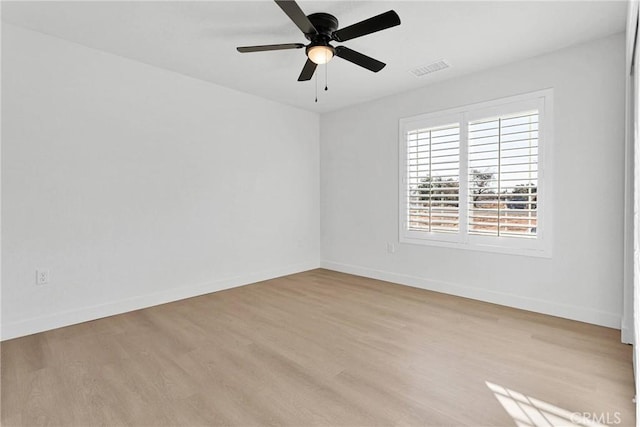 empty room featuring baseboards, a ceiling fan, visible vents, and light wood-type flooring