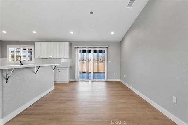 unfurnished living room featuring baseboards, visible vents, light wood-style flooring, and recessed lighting