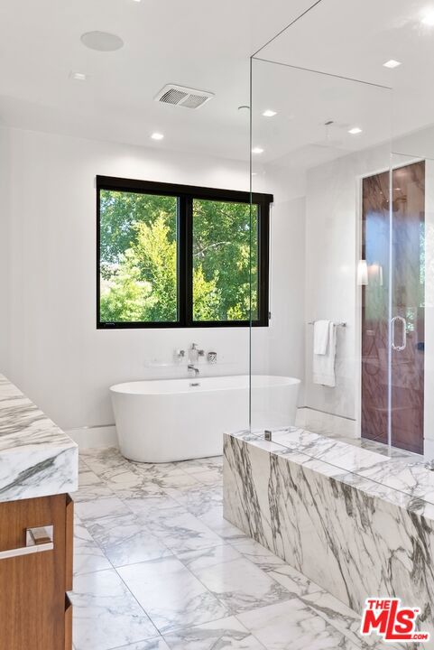 bathroom featuring vanity and separate shower and tub