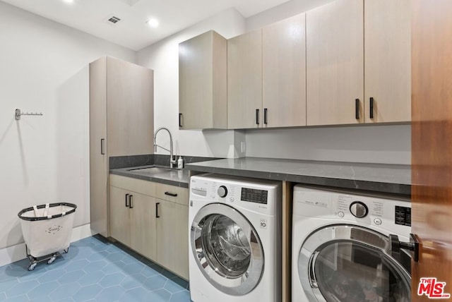 laundry room with sink, cabinets, independent washer and dryer, and dark tile patterned flooring