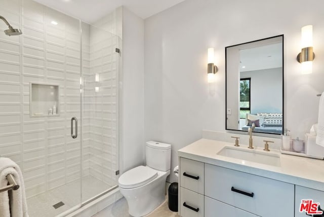 bathroom with vanity, a shower with door, and toilet