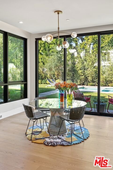 sunroom featuring plenty of natural light and an inviting chandelier