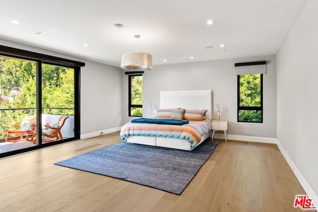 bedroom with multiple windows, access to exterior, and light hardwood / wood-style flooring