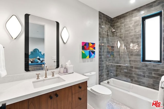 full bathroom featuring vanity, combined bath / shower with glass door, and toilet