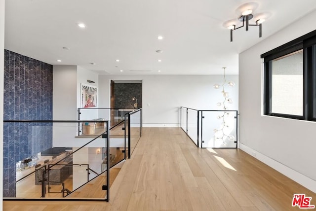 hall featuring a chandelier and light wood-type flooring