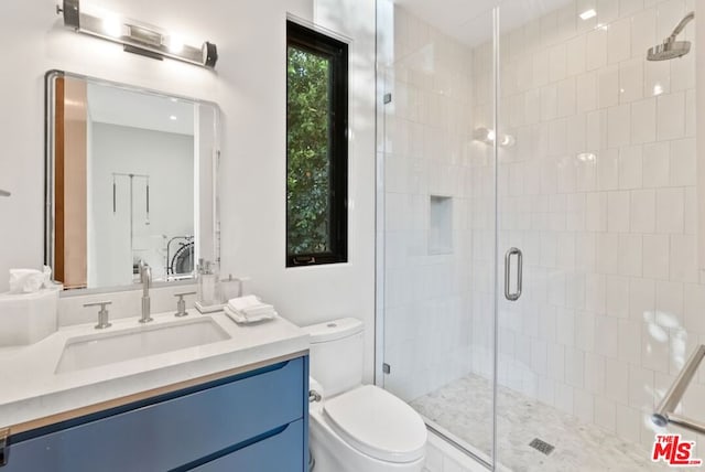 bathroom with vanity, toilet, and a shower with shower door