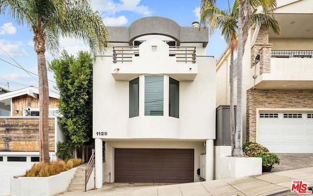 view of front of home featuring a garage and a balcony