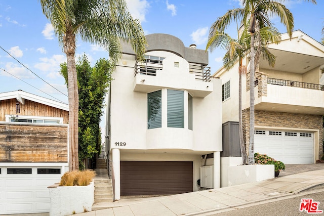 view of front of property featuring a balcony and a garage