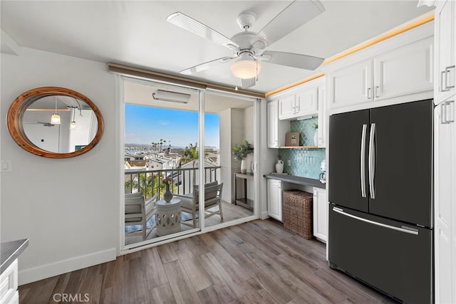 kitchen with white cabinetry, wood finished floors, a ceiling fan, and black refrigerator