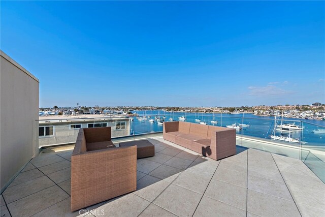 view of patio with outdoor lounge area, a balcony, and a water view