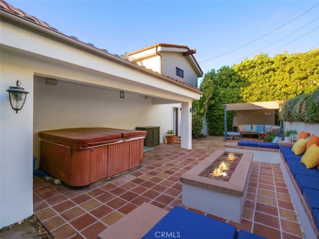 view of patio featuring a hot tub and an outdoor living space with a fire pit