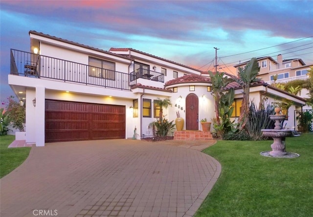 mediterranean / spanish house with a yard, a garage, and a balcony