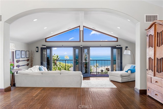 living room with vaulted ceiling with beams, a water view, visible vents, and hardwood / wood-style floors